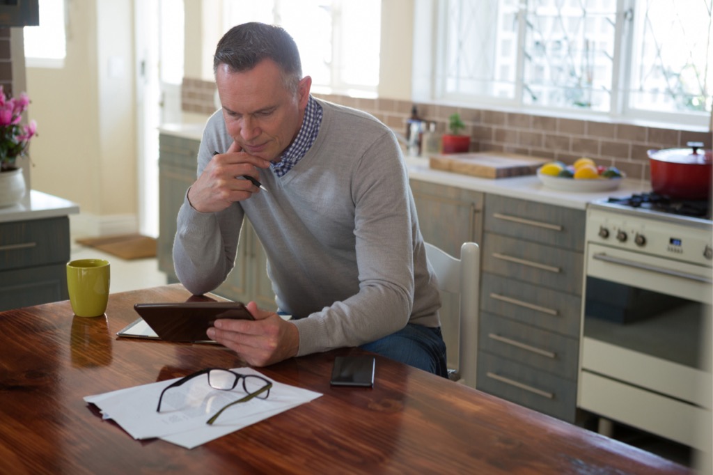 Man reviewing finances on tablet