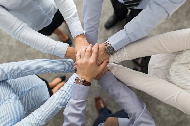 Coworkers with hands stacked view from the top of the pile