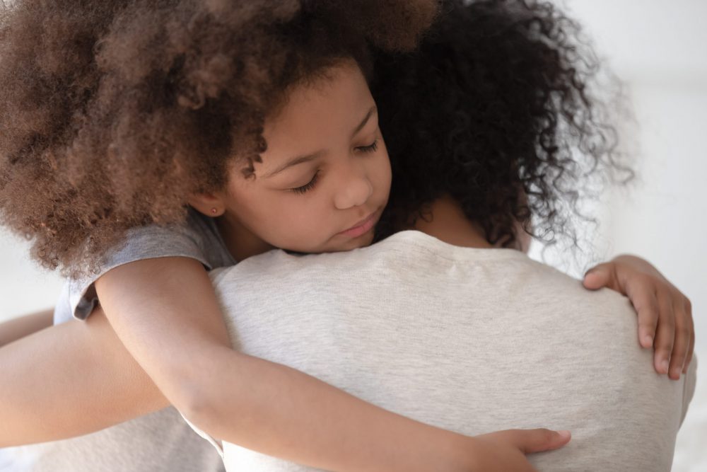 Mother and young daughter embracing